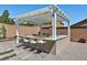 Outdoor kitchen with pergola, granite countertop and grill at 3870 Valles Caldera Ct, Las Vegas, NV 89118