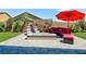 Backyard patio with fire pit, seating area and red umbrella at 3870 Valles Caldera Ct, Las Vegas, NV 89118