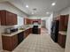 Kitchen with wood cabinets, black appliances, and tile floor at 6072 Corbin Ave, Las Vegas, NV 89122