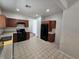 Kitchen boasts wood cabinets, black appliances, and tile floors at 6072 Corbin Ave, Las Vegas, NV 89122