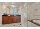 Bathroom vanity with dark cabinets, a large mirror, and glass shower at 135 E Harmon Ave # 1020, Las Vegas, NV 89109
