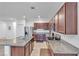 Spacious kitchen features dark wood cabinetry, stainless steel appliances, and a large island with granite countertops at 3558 E Malheur Ave, Pahrump, NV 89061