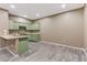 This kitchen offers pale green cabinets, a stainless steel sink, and vinyl flooring at 5655 E Sahara Ave # 1052, Las Vegas, NV 89142
