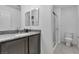 Modern bathroom featuring a sleek vanity with granite countertop and a glass-enclosed shower at 10664 Sariah Skye Ave, Las Vegas, NV 89166