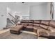 Cozy living room featuring a sectional sofa and staircase to upper level at 10664 Sariah Skye Ave, Las Vegas, NV 89166