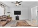 Cozy living room with a plush brown sectional, a mounted flat screen television, and neutral décor at 10664 Sariah Skye Ave, Las Vegas, NV 89166