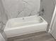 White bathtub with modern chrome faucet and gray laminate flooring at 4281 White Sands Ave, Las Vegas, NV 89121