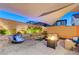 Relaxing backyard with a Buddha water feature, fire pit, and ambient lighting at 10407 Restless River St, Las Vegas, NV 89141
