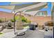 Outdoor patio area with a hanging egg chair, perfect for entertaining at 10407 Restless River St, Las Vegas, NV 89141