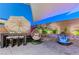 Cozy backyard featuring a dining table, egg chair, unique water feature, and accent lighting at 10407 Restless River St, Las Vegas, NV 89141