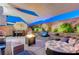 Backyard entertaining space with unique water feature, outdoor lighting, and a fire pit at 10407 Restless River St, Las Vegas, NV 89141