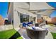 Stylish outdoor living space with modern patio furniture, a shade sail, and artificial turf at 10407 Restless River St, Las Vegas, NV 89141