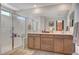 Modern bathroom featuring double vanity, glass shower and neutral decor at 10407 Restless River St, Las Vegas, NV 89141