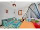 Eclectic bedroom features a bed, a canopy, living room area, and colorful throw pillows at 10407 Restless River St, Las Vegas, NV 89141