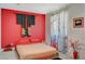 Asian-inspired bedroom featuring red accent wall and decorative window treatments at 10407 Restless River St, Las Vegas, NV 89141