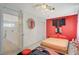 Bright bedroom with a walk-in closet, minimalist design and bright red accent wall at 10407 Restless River St, Las Vegas, NV 89141