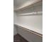 Spacious walk-in closet with wooden rods and shelving, offering ample storage space at 10407 Restless River St, Las Vegas, NV 89141
