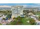 View of a high-rise condo building with amenities including a pool, tennis court, golf course, and lush greenery at 3111 Bel Air Dr # 28C, Las Vegas, NV 89109