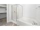 Bright bathroom with a glass enclosed shower, soaking tub, and tile surround at 98 Via Franello, Henderson, NV 89011