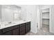 Modern bathroom featuring double sinks, a walk-in shower and a spacious walk-in closet at 98 Via Franello, Henderson, NV 89011