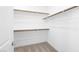 Walk-in closet features shelves with wooden rods and neutral carpet at 98 Via Franello, Henderson, NV 89011