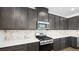 Kitchen featuring quartz countertops, stainless steel appliances, and dark cabinets at 98 Via Franello, Henderson, NV 89011