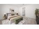 Staged main bedroom with an upholstered bed, accent furniture, and en-suite bathroom at 98 Via Franello, Henderson, NV 89011