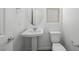 Powder room with pedestal sink, toilet, and oval mirror at 98 Via Franello, Henderson, NV 89011