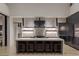 Modern kitchen island with marble countertops and dark cabinetry at 9 Boulderback Dr, Henderson, NV 89012