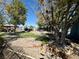 Landscaped backyard featuring a covered patio and mature trees providing ample shade at 3895 Mountain Trl, Las Vegas, NV 89108