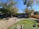 Large backyard with mature trees, play area, seating, and a sun room at 3895 Mountain Trl, Las Vegas, NV 89108