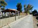 A covered gazebo provides an outdoor retreat within a fenced yard under a clear blue sky at 3895 Mountain Trl, Las Vegas, NV 89108