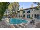 Back exterior view of home featuring outdoor swimming pool with jacuzzi and lush landscaping at 4156 Balmoral Castle Ct, Las Vegas, NV 89141