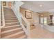 Grand foyer features a staircase with glass railing and tile flooring at 4156 Balmoral Castle Ct, Las Vegas, NV 89141