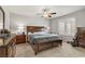 Bedroom with plush carpet, ceiling fan, a large bed with drawers, and a window with plantation shutters at 8351 Gold River Ct, Las Vegas, NV 89113