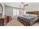 Bedroom with plush carpet, a ceiling fan, a large bed with drawers, and a window with plantation shutters at 8351 Gold River Ct, Las Vegas, NV 89113