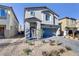 Two-story house with a gray facade, blue garage door, and landscaped front yard at 8351 Gold River Ct, Las Vegas, NV 89113