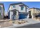 Two-story home with a blue front door, a blue two-car garage door, and desert landscaping at 8351 Gold River Ct, Las Vegas, NV 89113