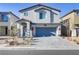 Well maintained two-story home with a blue garage door and landscaped front yard at 8351 Gold River Ct, Las Vegas, NV 89113