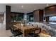 Stylish kitchen and dining space with a marble island, wooden table, and modern black chairs at 12 Chisel Crest Ct, Henderson, NV 89012