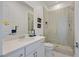 Well-lit bathroom featuring a glass shower with gray tiling, a white vanity, and modern fixtures at 12295 Skyracer Dr, Las Vegas, NV 89138