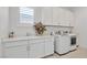 Functional laundry room with ample cabinetry, sink, and modern washer and dryer at 12295 Skyracer Dr, Las Vegas, NV 89138