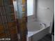 Bathroom featuring a soaking tub with unique tile shower and a window providing natural light at 4085 Oliver Sagebrush Dr, Las Vegas, NV 89122