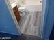 Modern bathroom with wood-look flooring, toilet, and tub with a shower head at 4085 Oliver Sagebrush Dr, Las Vegas, NV 89122