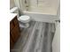 Modern bathroom with wood-look flooring, toilet, and tub with a shower head at 4085 Oliver Sagebrush Dr, Las Vegas, NV 89122