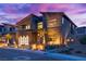 Modern home with stone accents and a three-car garage at dusk at 10632 Patina Hills Ct, Las Vegas, NV 89135