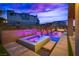 Luxury pool and spa with multiple waterfall features at dusk at 10632 Patina Hills Ct, Las Vegas, NV 89135