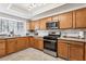 Bright kitchen featuring wooden cabinetry, stainless steel appliances, and granite countertops at 3933 Edgemoor Way, Las Vegas, NV 89121