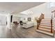 Spacious living room featuring wood floors, a white sofa, a chandelier, and a staircase at 3933 Edgemoor Way, Las Vegas, NV 89121