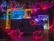 Night view of house, pool, and lush landscaping with colorful lights at 3784 Pama Ln, Las Vegas, NV 89120